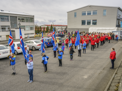 Scouts and a school band prepare to lead a parade in Bústaðahverfi for First Day of Summer