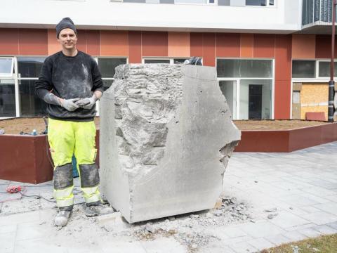 Maður við stein.