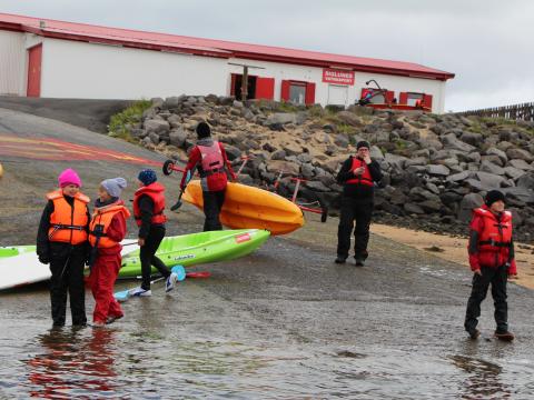 Participants hold kayaks during a Siglunes summer course.