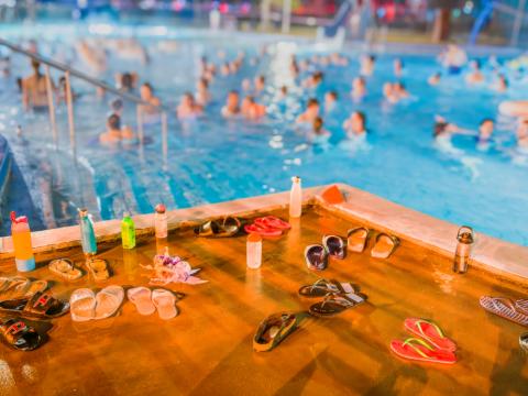 A crowded swimming pool with swimmers partially visible