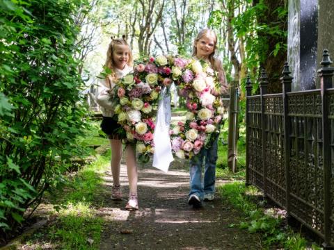 Friends Jóný Helgadóttir and Nína Melkorka Ólafsdóttir carry the wreath to the grave of Bríet Bjarnhéðinsdóttir at Hólavallagarður.