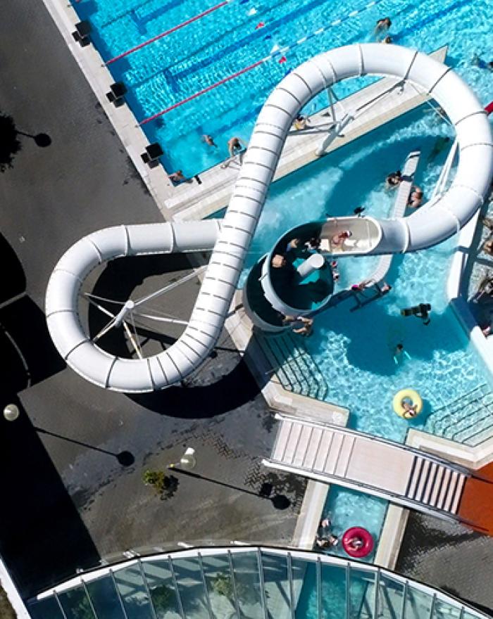 Aerial view of slide, hot tubs, and outdoor pool at Árbæjarlaug.