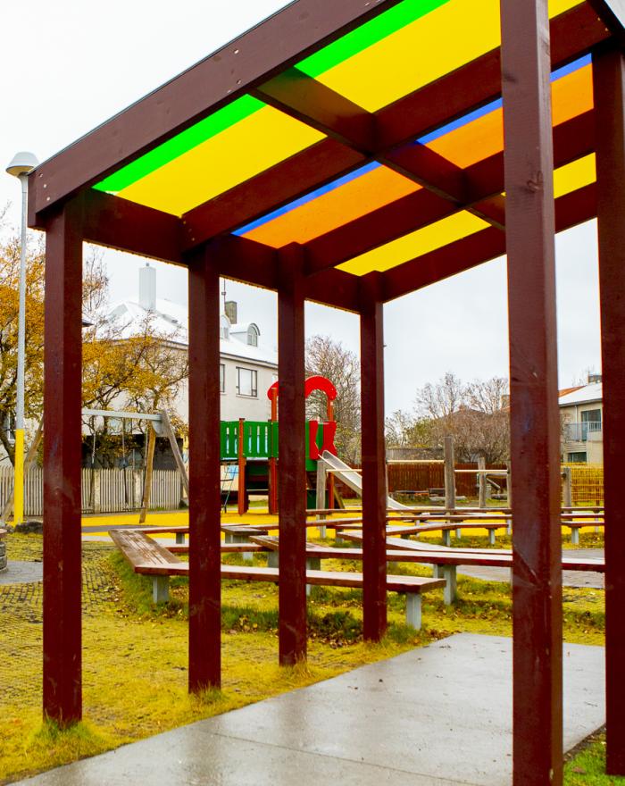 Shelter with multicolored glass panels in the outdoor area at Hlíðar preschool