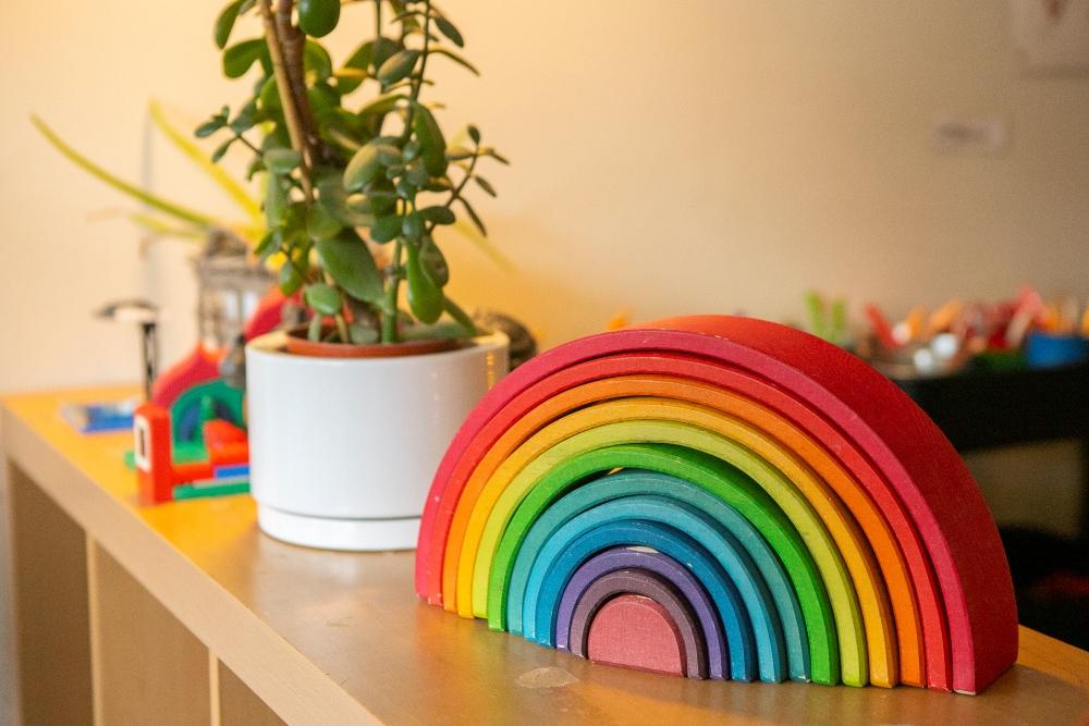 Rainbow tree toy and potted plant on a shelf at Bjartahlíð preschool
