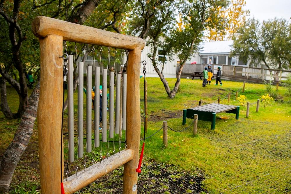 Outdoor musical instruments with children playing in the background