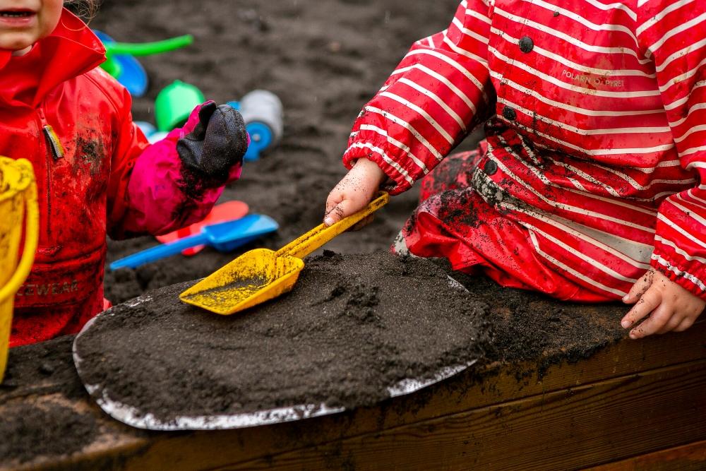 Child digging with a shovel in the sandbox 
