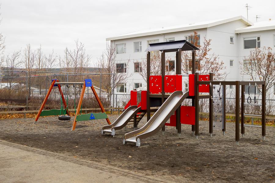 Play castle with slides and swings in the outdoor play area at Sunnufold preschool