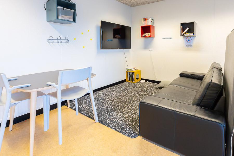 Sofa in front of television on wall. 