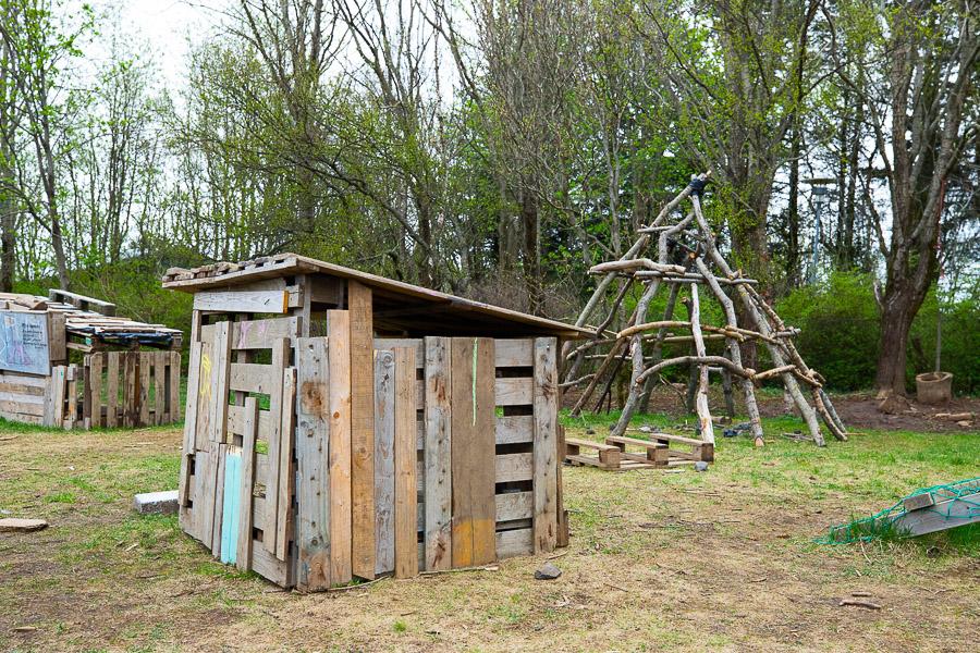 A wooden hut and jungle gym in the Dalheimar after-school program's outdoor area