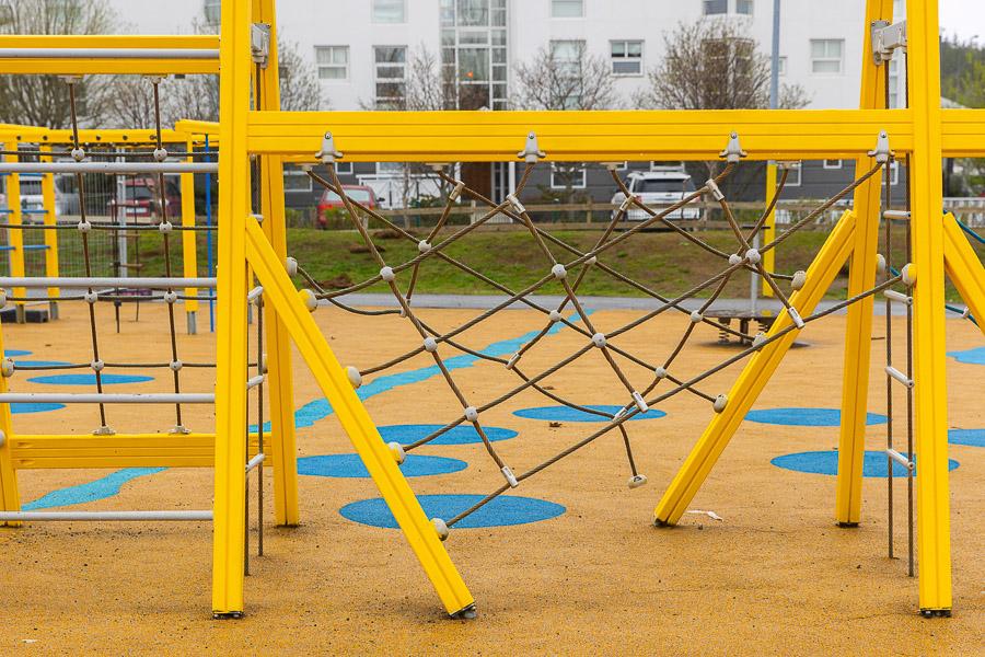 Yellow jungle gyms with ropes. Yellow-painted walkway with blue circles. 
