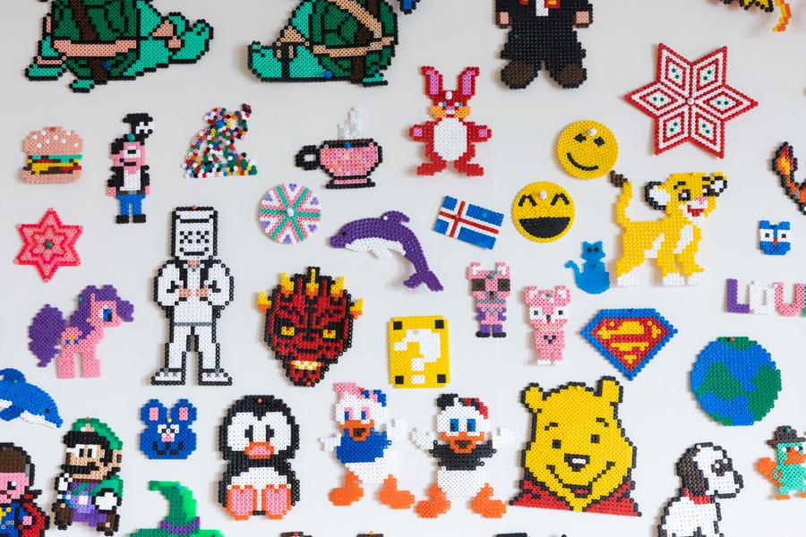 Figures made from Perler beads on a wall.