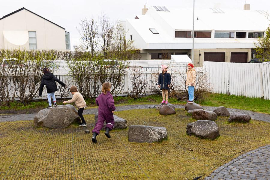 A group of children playing on rocks in Undraland's outdoor area.