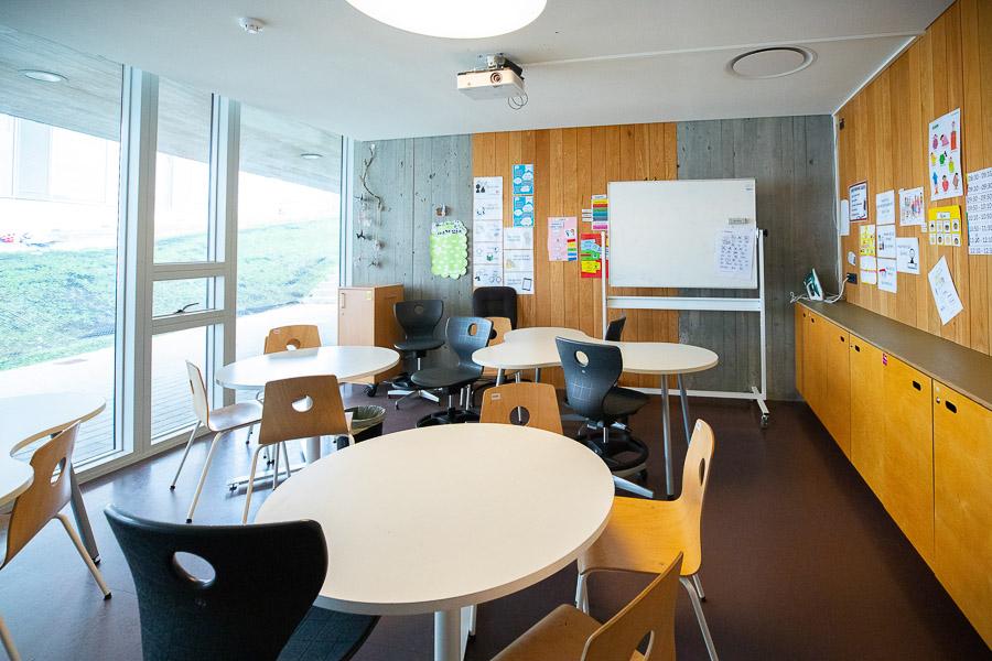 Round tables with chairs and whiteboard. 