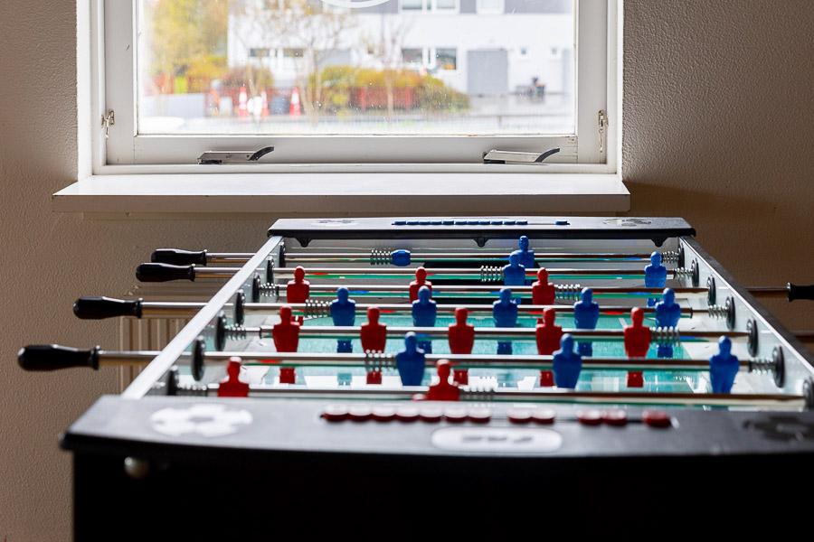 A foosball table and a window in the background.