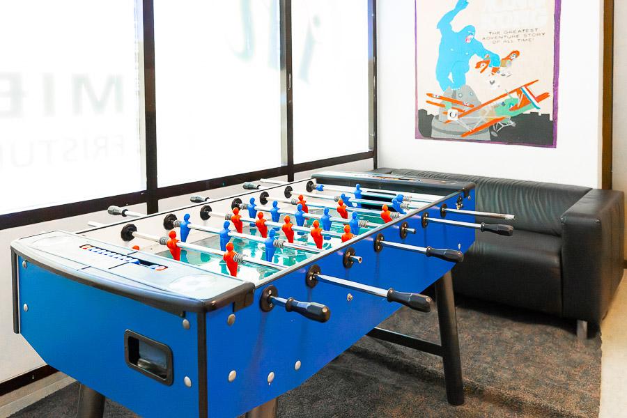 A foosball table and a black sofa.