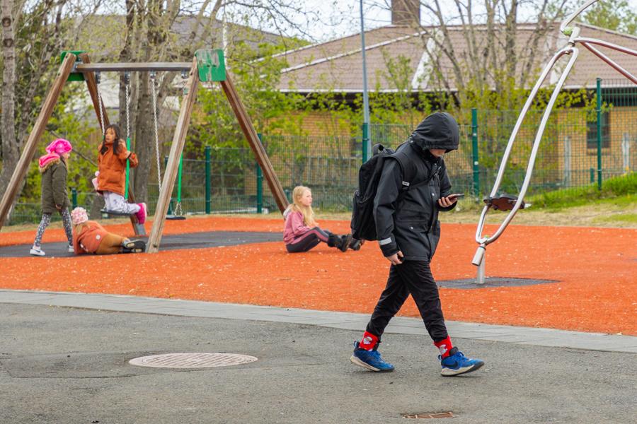 Children on a playground with swings. 