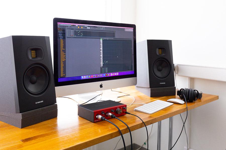 Table with computer, sound recording equipment and speakers.
