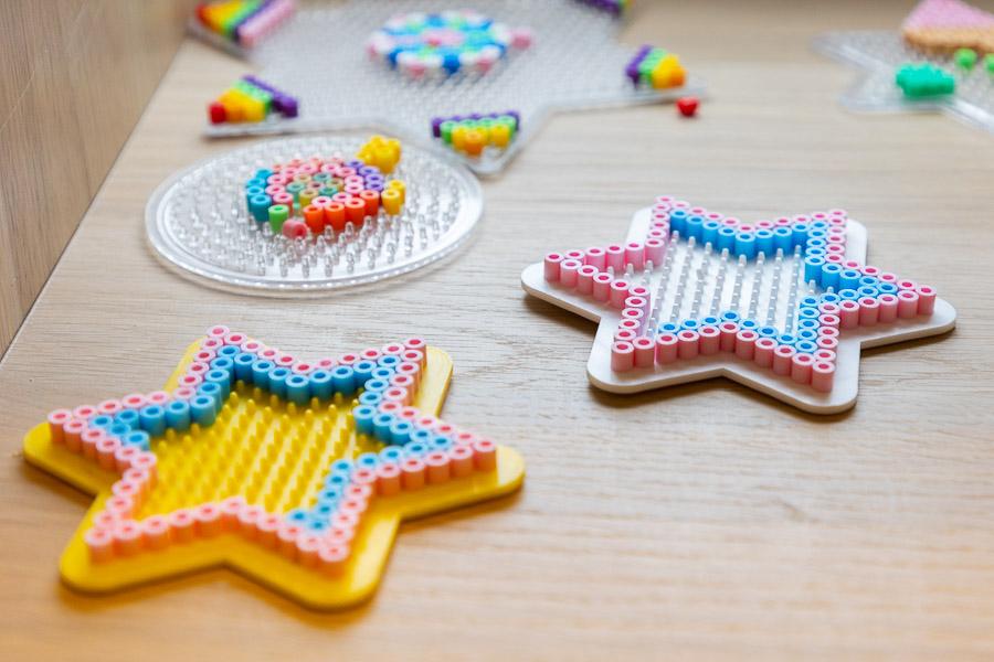 Perler bead boards and beads on a table. 