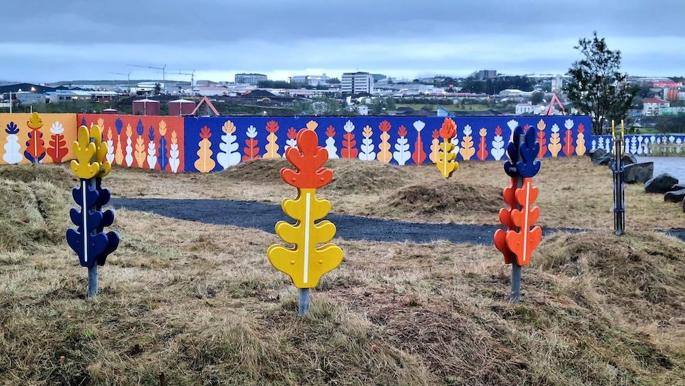 Colorful sculptures, painted wall and grass.