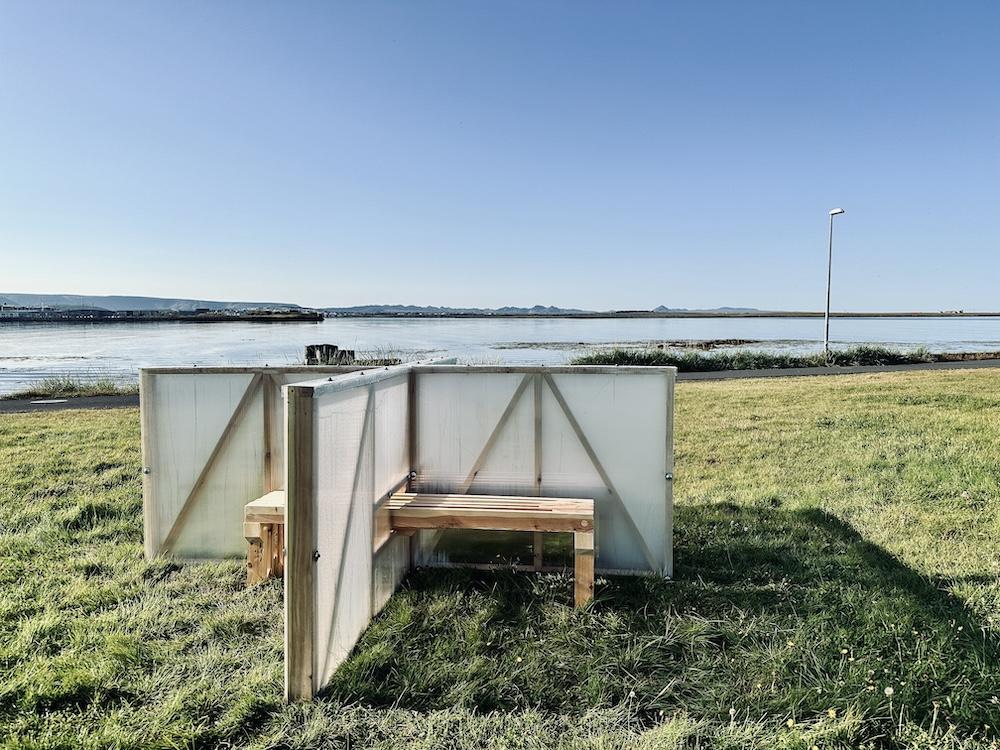 Grass, benches and partitions by the sea.