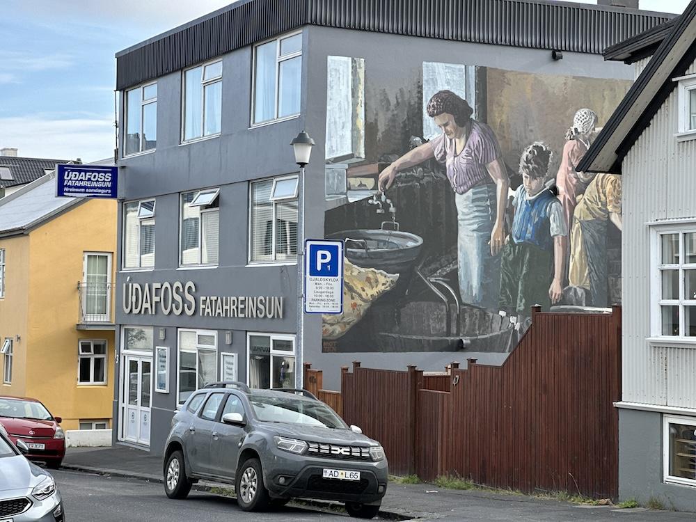 Car, house and artwork on wall.