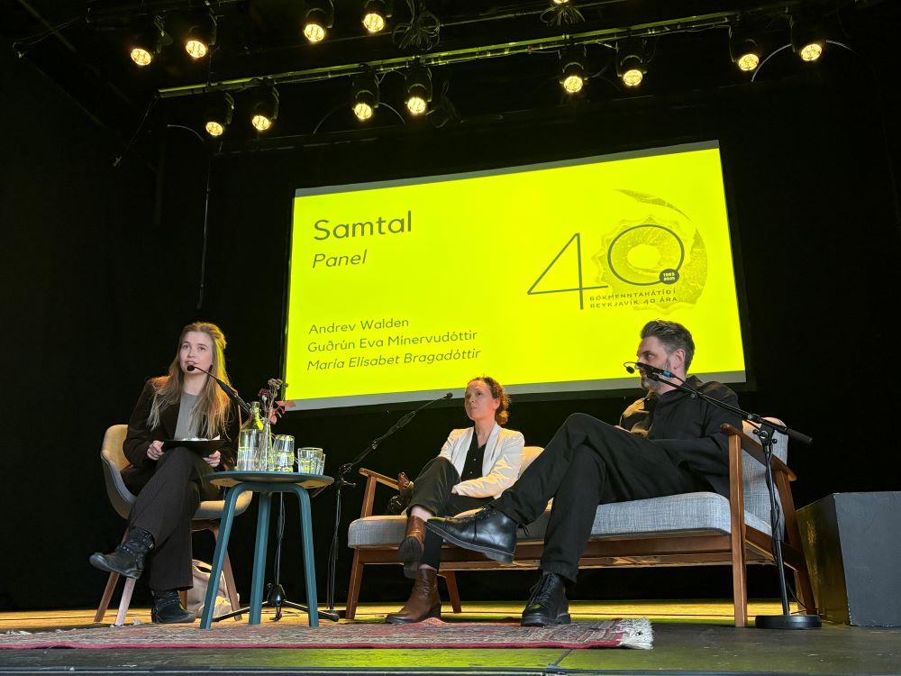 Þrjár manneskjur tala saman á sviði