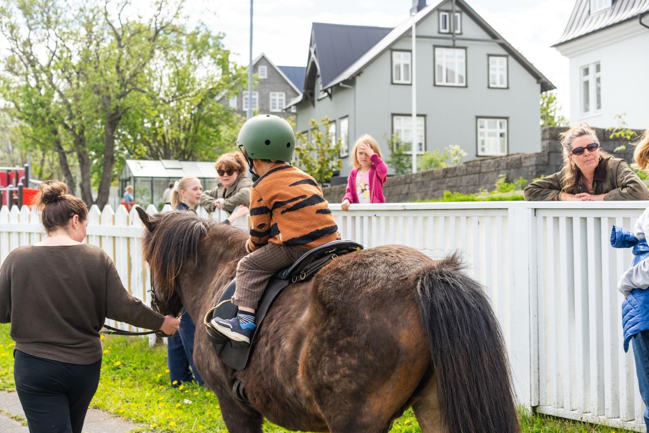 A child on horseback surrounded by adults.