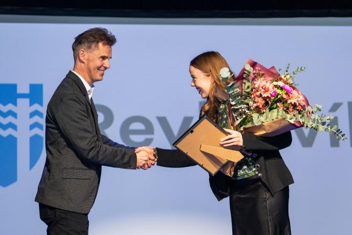 Cultural and Sports Council Chair Skúli Þór Helgason presents the grant and flowers to Anna E. Sigurðardóttir from Elja's board at Iðnó.