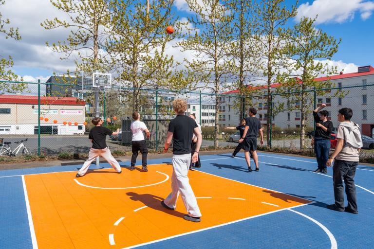 Young people playing basketball on the court.