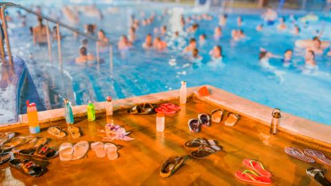 A crowded swimming pool with swimmers partially visible