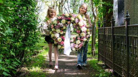 Friends Jóný Helgadóttir and Nína Melkorka Ólafsdóttir carry the wreath to the grave of Bríet Bjarnhéðinsdóttir at Hólavallagarður.