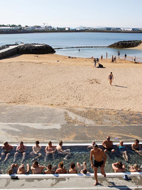 View over the hot tub, the warm beach and out to Fossvogur